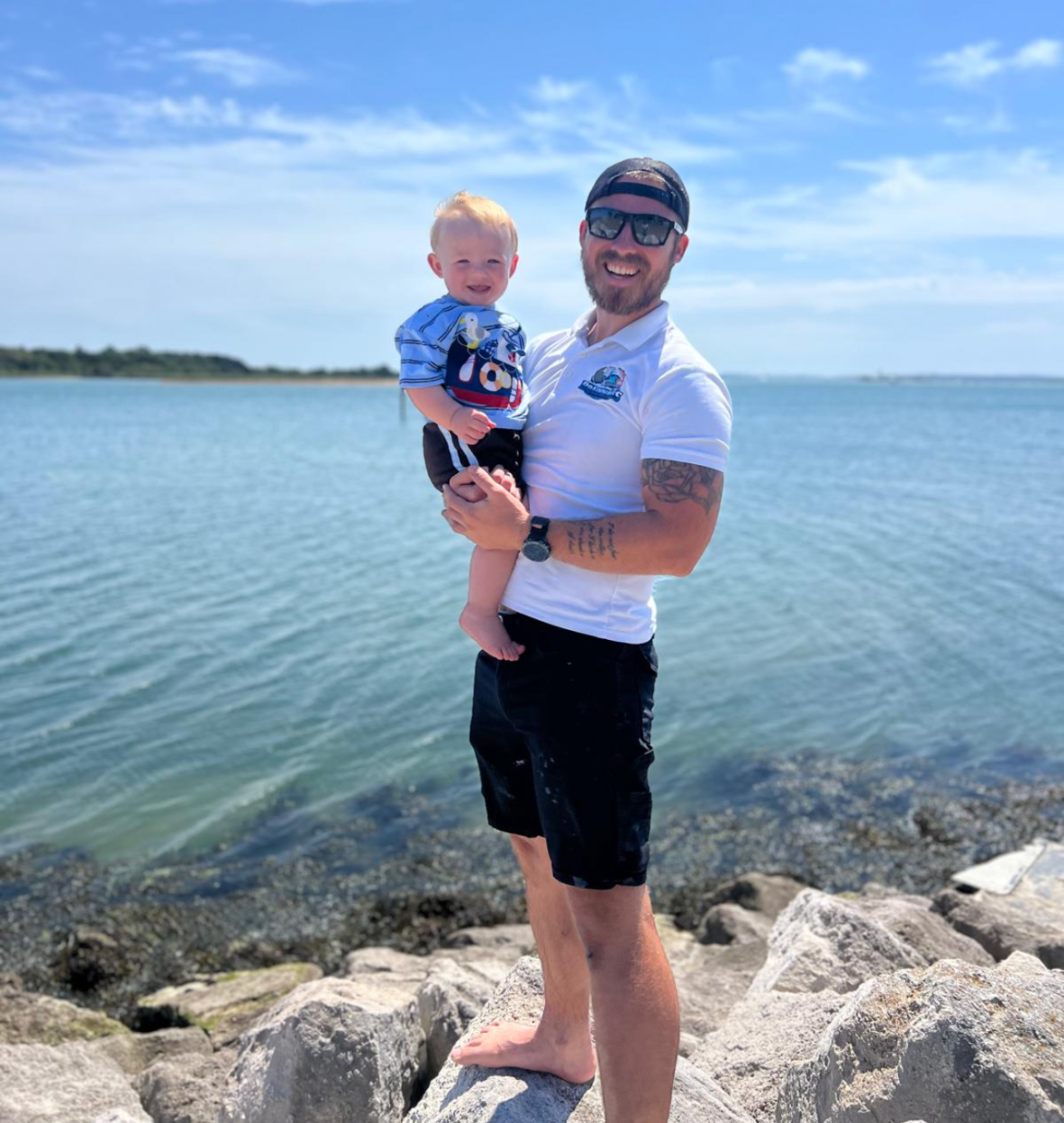 Danny, founder of BrainWaves GRP, with his child beside the water